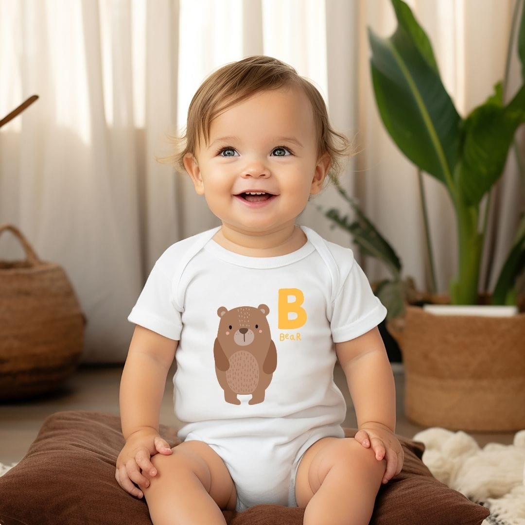 a baby sitting on the floor wearing a bear shirt
